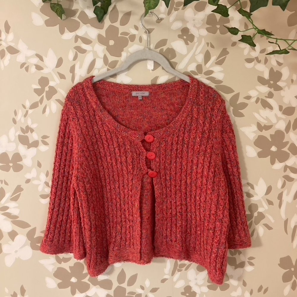 pink knitted cropped shirt with buttons and three quarter length sleeves.